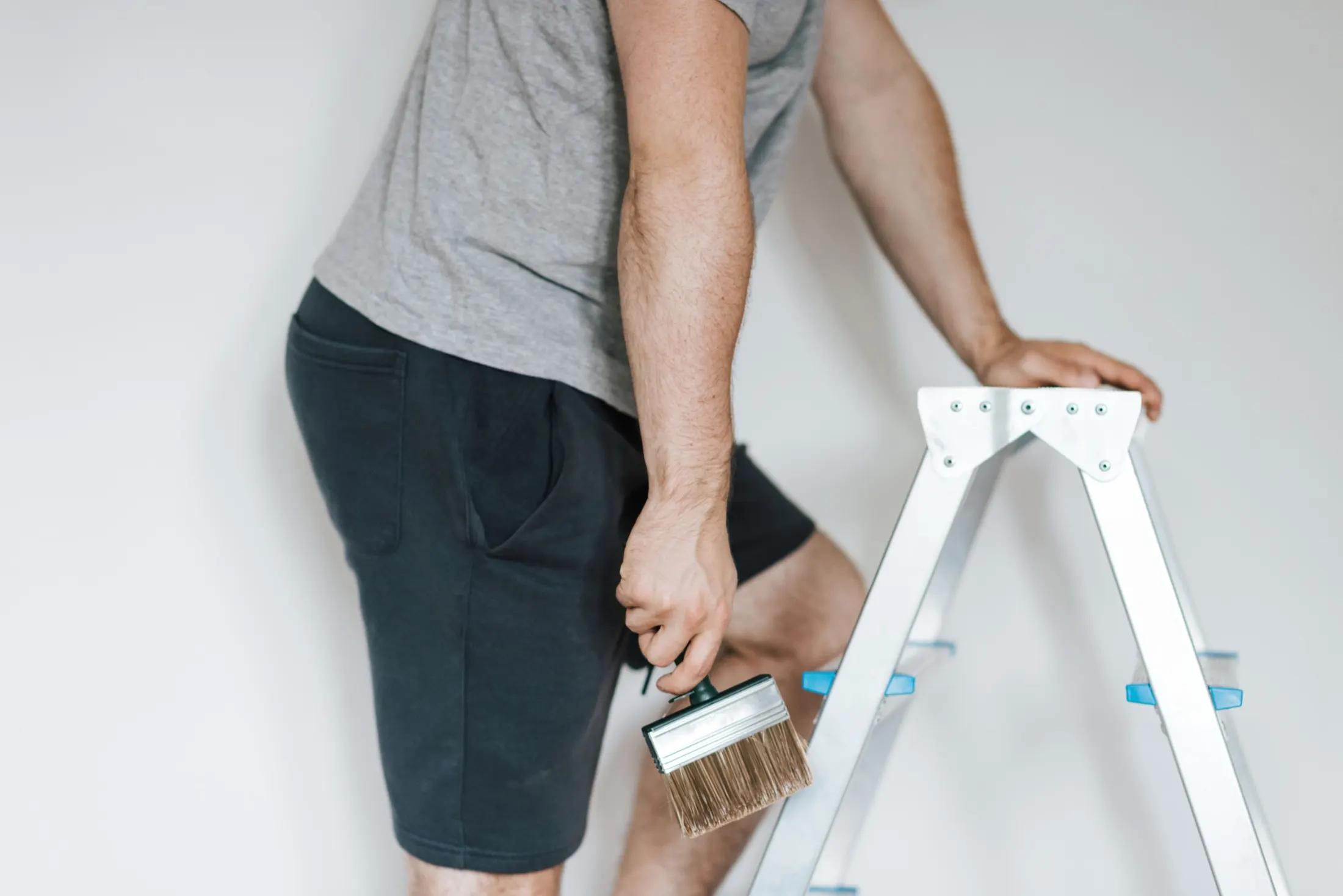 Painter beside a stepladder in a light room